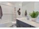 This bathroom includes a bathtub with a shower, a sink, and decorative baskets hanging on the wall at 3335 S Lily Ave, Mesa, AZ 85212