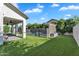 Beautiful backyard showcasing the covered patio, pool with fence, green lawn, and lush landscaping at 3415 E Arabian Dr, Gilbert, AZ 85296