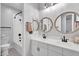 Bathroom with dual sinks, decorative mirrors, and tub shower combo at 3415 E Arabian Dr, Gilbert, AZ 85296