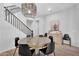 The dining room features a modern chandelier, seating for six, and easy access to the staircase at 3415 E Arabian Dr, Gilbert, AZ 85296