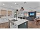 Open kitchen with an island bar, stainless steel sink, and connection to the living area at 3415 E Arabian Dr, Gilbert, AZ 85296