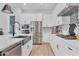 Bright kitchen features stainless steel appliances, white cabinets, light wood floors, and a farmhouse sink at 3415 E Arabian Dr, Gilbert, AZ 85296