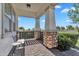 Covered porch with stone columns, brick flooring, and a cozy seating area at 3415 E Arabian Dr, Gilbert, AZ 85296