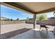 Large backyard with gravel landscaping, block wall fence, and covered patio at 42180 W Cheyenne Dr, Maricopa, AZ 85138