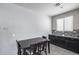 This dining area showcases a table with black wood and stylish cabinets beneath a window in a modern style at 42180 W Cheyenne Dr, Maricopa, AZ 85138
