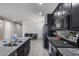 Kitchen featuring stainless steel appliances, granite countertops, dark cabinets, and tiled floor, with a view to the dining area at 42180 W Cheyenne Dr, Maricopa, AZ 85138