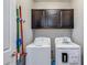 The laundry room features a washing machine, dryer, and overhead cabinets for storage at 42180 W Cheyenne Dr, Maricopa, AZ 85138