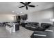 Open-concept kitchen and living area featuring dark cabinets, a ceiling fan, and plush leather seating for ultimate comfort at 42180 W Cheyenne Dr, Maricopa, AZ 85138