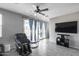 Relaxing living room with a ceiling fan, modern decor, and sliding glass doors to the backyard at 42180 W Cheyenne Dr, Maricopa, AZ 85138