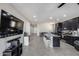 Open concept area featuring tiled floors, a kitchen with an island, and comfortable seating for entertaining at 42180 W Cheyenne Dr, Maricopa, AZ 85138