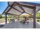 Covered picnic tables with playground equipment and green space in the background at 42180 W Cheyenne Dr, Maricopa, AZ 85138