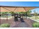 Well-maintained playground featuring a shade canopy and various play structures at 42180 W Cheyenne Dr, Maricopa, AZ 85138