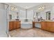 Bright main bathroom featuring glass block window, separate vanities, and soaking tub at 4305 S Antonio --, Mesa, AZ 85212