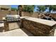 An outdoor kitchen features a built-in stainless steel grill and stacked stone surround, perfect for entertaining at 4305 S Antonio --, Mesa, AZ 85212
