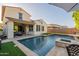 Stunning backyard with a refreshing pool, travertine deck, covered patio, and well-maintained artificial turf at 4337 S Helix --, Mesa, AZ 85212