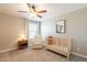 A Bedroom with soft carpeting, a ceiling fan, a white chair, and a crib at 4337 S Helix --, Mesa, AZ 85212