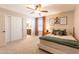 A bright bedroom with carpeted floors, a ceiling fan, and an adjoining bathroom through an open doorway at 4337 S Helix --, Mesa, AZ 85212