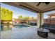 Covered patio featuring travertine flooring, stylish furniture, and a view of the refreshing pool and backyard at 4337 S Helix --, Mesa, AZ 85212