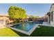 Resort-style pool with a travertine deck, lush turf, mature landscaping, and an outdoor kitchen and seating area at 4337 S Helix --, Mesa, AZ 85212