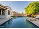 A stunning backyard pool with water feature, travertine tile surround, and artificial grass at 4337 S Helix --, Mesa, AZ 85212
