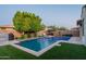 Relaxing backyard oasis featuring a sparkling pool, travertine deck, lush turf, and outdoor BBQ and seating area at 4337 S Helix --, Mesa, AZ 85212