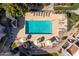Aerial view of community pool with lounge chairs, umbrellas, and landscaped surroundings at 4554 E Paradise Village Pkwy # 267, Phoenix, AZ 85032