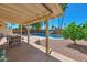 Covered patio offering an outdoor dining space with views of the sparkling pool and lush backyard at 4815 E Everett Dr, Scottsdale, AZ 85254