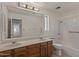 Bathroom featuring dual sinks, a shower and tub combo, and wood cabinets at 509 W Boxelder Pl, Chandler, AZ 85225