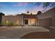 Charming single-story home with a red tile roof, neutral stucco, and a spacious driveway at sunset at 509 W Boxelder Pl, Chandler, AZ 85225