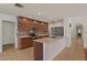 Kitchen features dark cabinets, stainless steel appliances, and island with white countertop at 509 W Boxelder Pl, Chandler, AZ 85225