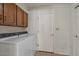 Well-lit laundry room featuring wooden cabinets and modern washer and dryer at 509 W Boxelder Pl, Chandler, AZ 85225