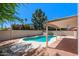Landscaped backyard featuring a sparkling pool, covered patio, and manicured lawn at 509 W Boxelder Pl, Chandler, AZ 85225