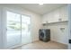 Laundry room with modern washer and dryer, cabinets, and sliding glass doors to the pool at 520 N 23Rd St, Mesa, AZ 85213