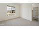 Bedroom includes neutral carpet, white walls, and a window overlooking the neighborhood at 5533 N 193Rd Ave, Litchfield Park, AZ 85340