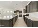 Open kitchen with dark cabinetry, stainless appliances, tile backsplash and a large center island with seating at 5533 N 193Rd Ave, Litchfield Park, AZ 85340