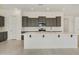 Well-lit kitchen with a large island, dark cabinets, and stainless steel appliances at 5533 N 193Rd Ave, Litchfield Park, AZ 85340
