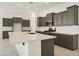 Modern kitchen featuring dark cabinets, stainless steel appliances, and a large quartz countertop island at 5533 N 193Rd Ave, Litchfield Park, AZ 85340