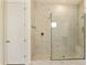 This primary shower features marble look tiling, glass door, and built-in bench at 5533 N 193Rd Ave, Litchfield Park, AZ 85340