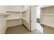 Large walk-in closet with built-in shelving and convenient access to the bathroom at 5533 N 193Rd Ave, Litchfield Park, AZ 85340