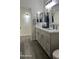 Bright bathroom with a double sink vanity, modern fixtures, and gray wood-look flooring at 6421 S 23Rd Dr, Phoenix, AZ 85041