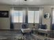 Cozy living room with accent chairs, stylish rug, and natural light from the large windows at 6421 S 23Rd Dr, Phoenix, AZ 85041