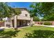 Backyard with a covered patio, green lawn, a playhouse, and stucco house exterior at 6657 W Aurora Dr, Glendale, AZ 85308