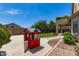 Backyard featuring a charming red playhouse, lush lawn, and covered patio at 6657 W Aurora Dr, Glendale, AZ 85308