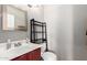 Small bathroom with a red vanity, sink and modern shelf for toiletries above the toilet at 6657 W Aurora Dr, Glendale, AZ 85308