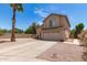 Charming home with gravel landscaping, palm tree, long driveway leading to a two-car garage, and a sunny sky at 6657 W Aurora Dr, Glendale, AZ 85308