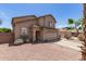 A tan home with well-kept gravel landscaping, a two-car garage, and a charming arched entryway at 6657 W Aurora Dr, Glendale, AZ 85308