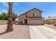 Two-story home featuring a two-car garage, gravel landscaping, and a unique palm tree in the front yard at 6657 W Aurora Dr, Glendale, AZ 85308