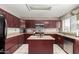 U-shaped kitchen featuring granite countertops, stainless steel appliances, and dark wood cabinetry at 6657 W Aurora Dr, Glendale, AZ 85308