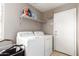 Well-equipped laundry room with washer, dryer, and overhead shelving for organized convenience at 6657 W Aurora Dr, Glendale, AZ 85308
