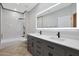 Bathroom featuring a dual vanity, granite countertops, and a shower with white marble tiling at 6672 E Horned Owl Trl, Scottsdale, AZ 85266